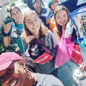 Members of our youth group, smiling for the camera and holding up supplies they are taking to donate.